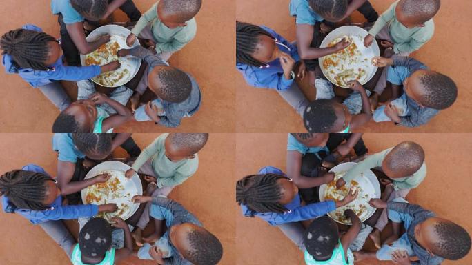 非洲的贫困。饥饿的非洲黑人儿童从公共炊具的底部刮去食物残渣