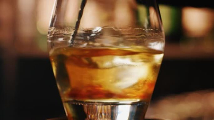 专业调酒师的特写镜头正在酒吧或迪斯科俱乐部为顾客混合酒精鸡尾酒和专业水晶持久冰块。