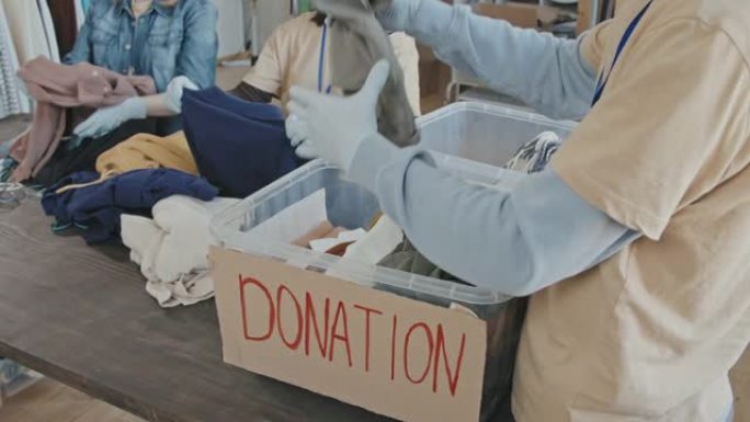 志愿者用衣服整理捐赠容器