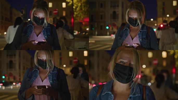 晚上在罗马的大街上使用智能手机戴着口罩的SLO MO女人
