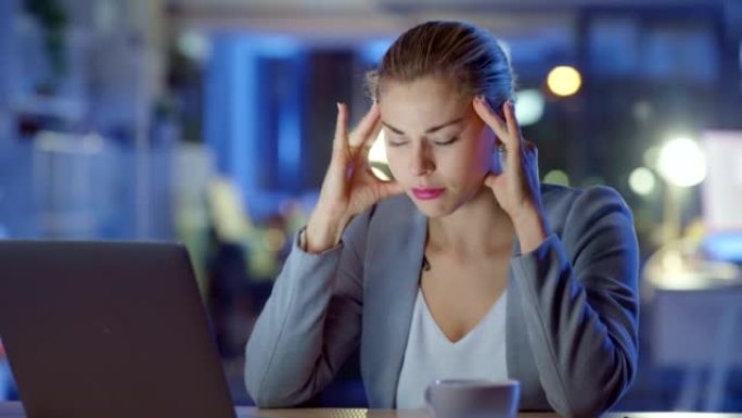 女商人在深夜感到疲惫和沮丧的同时头痛。压力和焦虑导致工作崩溃，同时在公司办公室工作到最后期限