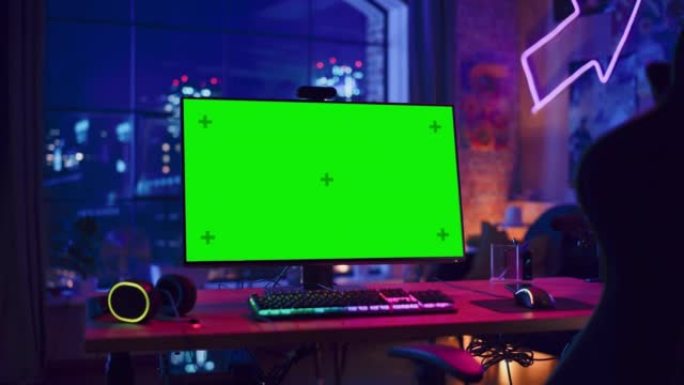 在家玩游戏: 空的游戏站，玩家的个人电脑，绿屏色度键显示站在带霓虹灯的时尚阁楼公寓的木桌上。放大镜头