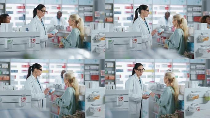 药房: 专业的高加索药剂师帮助美丽的高级女性顾客推荐，建议，交谈。药店里到处都是药物，药丸，保健，美