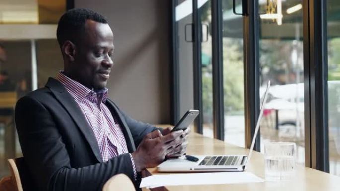 快乐的非洲商人在办公室使用手机