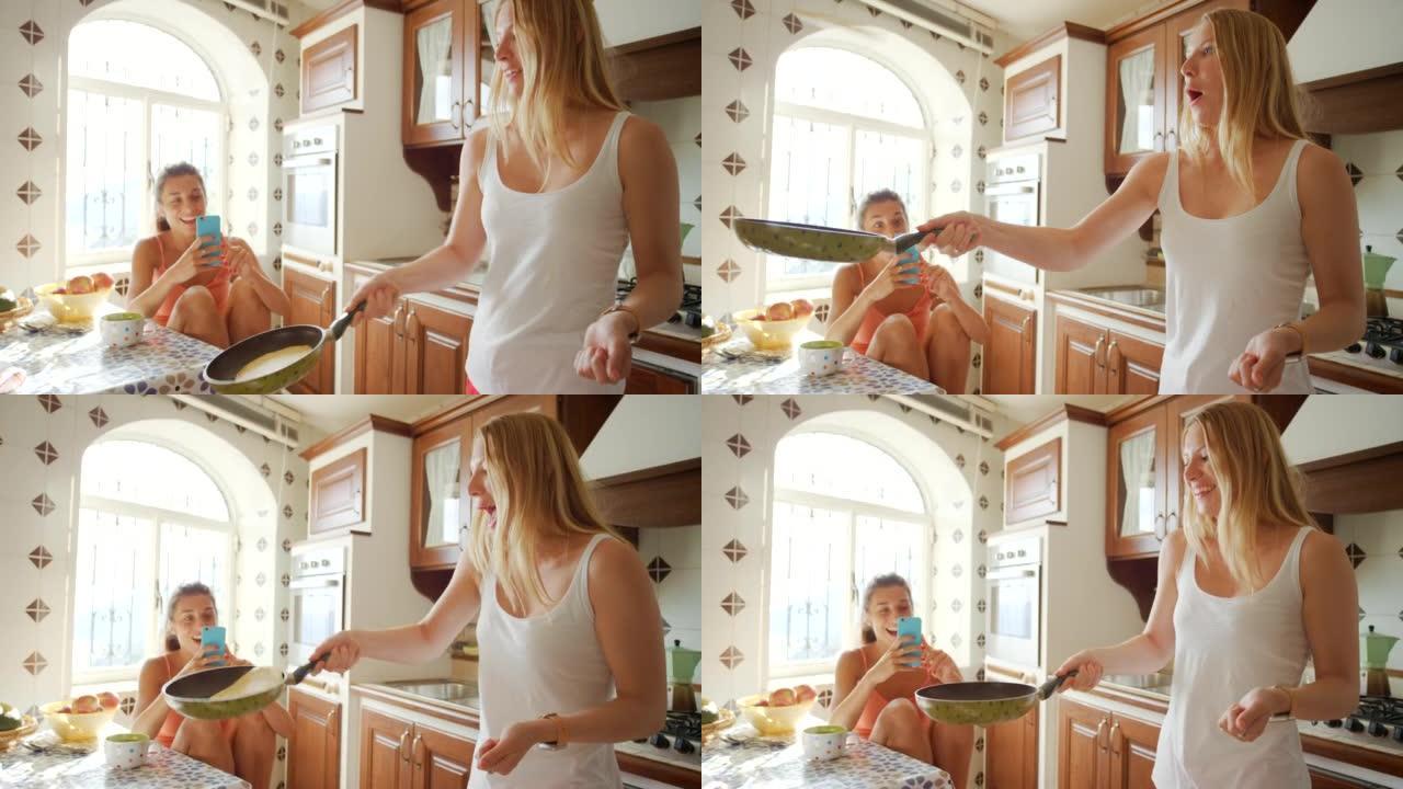 一个快乐的女人在翻转煎饼时被记录在手机上
