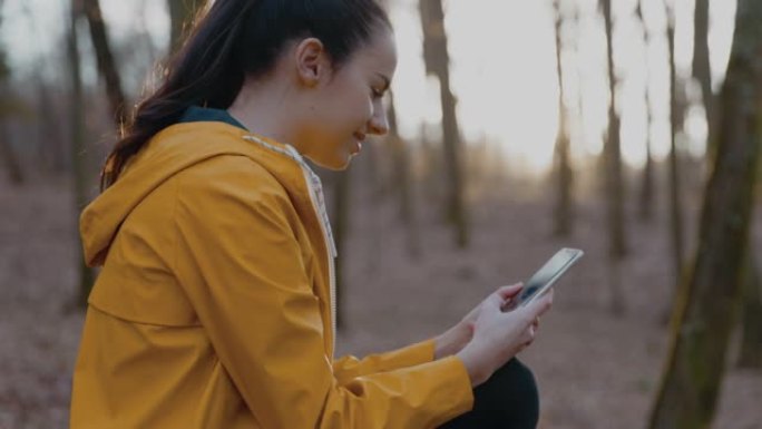 体贴的女人在森林里使用手机