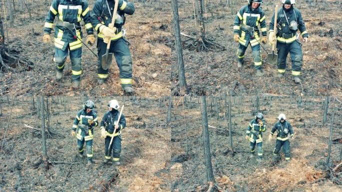 两名穿着安全服装的消防员正穿过森林火区