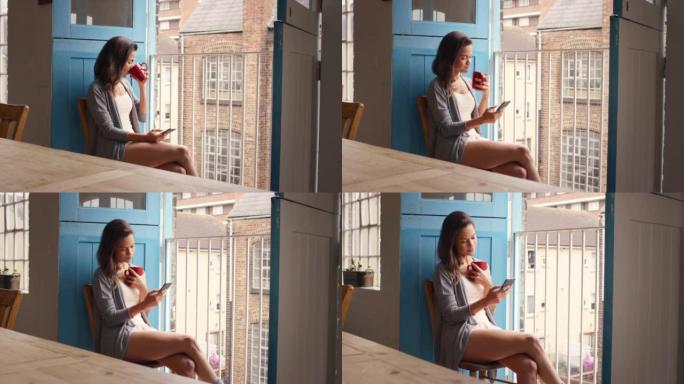 4k视频片段，一名年轻女子在家中喝咖啡时使用电话