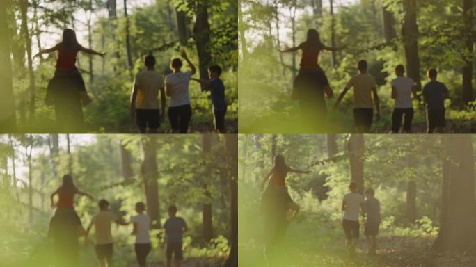 SLO MO一家带着三个孩子在阳光明媚的森林中散步