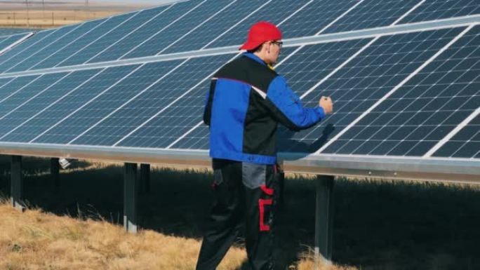 男工程师正在检查太阳能电池板。可再生能源、太阳能发电厂、绿色电力概念。
