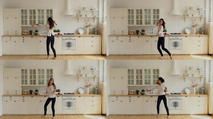 在现代宽敞的厨房里，活泼的家庭主妇赤脚唱歌跳舞