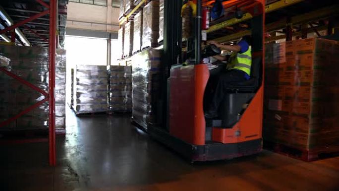 多莉开枪: 男性叉车操作员司机在仓库里拿托盘