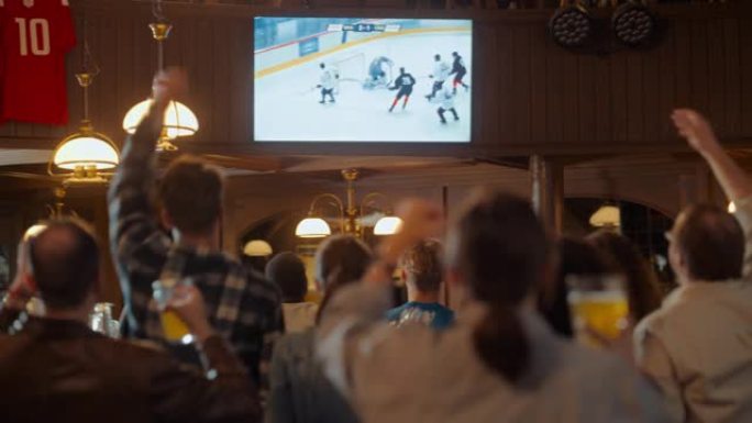 一群冰球球迷在电视上的体育酒吧观看现场比赛。人们欢呼，支持他们的团队。当球队进球并赢得冠军时，人群会