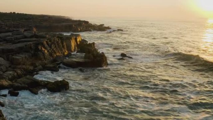 日落时分，在南非东开普省姆坎巴蒂自然保护区崎rock不平的岩石海滩海岸线上的海浪的鸟瞰图