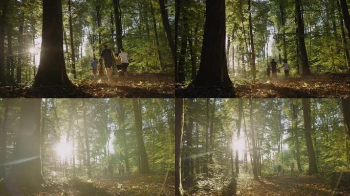 有三个孩子的SLO MO家庭在阳光明媚的森林中奔跑