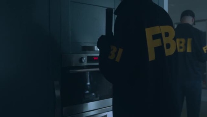 FBI探员在暗室里打开橱柜