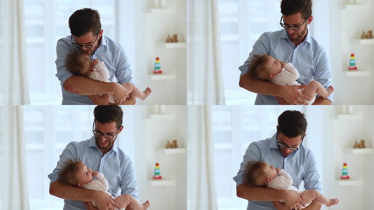 快乐帅气的新爸爸抱着可爱的宝宝