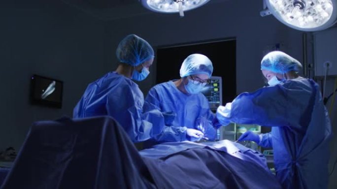 医院手术室中戴着手术帽和口罩的多元化外科医生