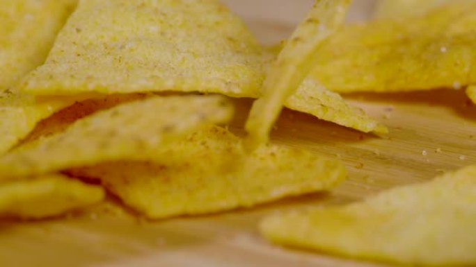 宏观: 三角形金色玉米饼片落在木质表面上。