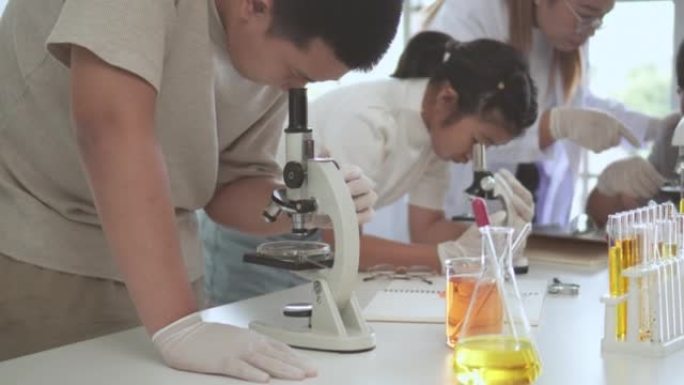 学生们高兴地用显微镜学习科学科目。