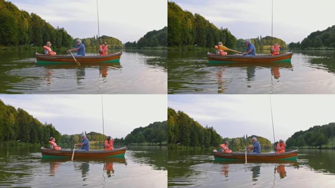 祖父和孙子坐在划船上在湖上钓鱼