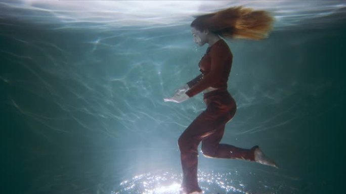 令人难以置信的电影镜头，年轻美丽的舞者在水下倒立行走，脚在水面上慢动作