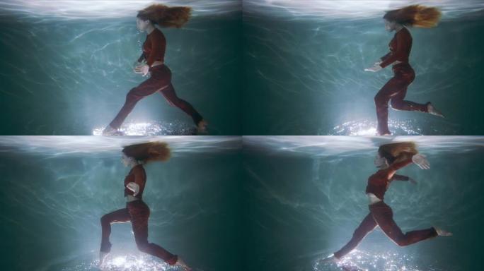 令人难以置信的电影镜头，年轻美丽的舞者在水下倒立行走，脚在水面上慢动作