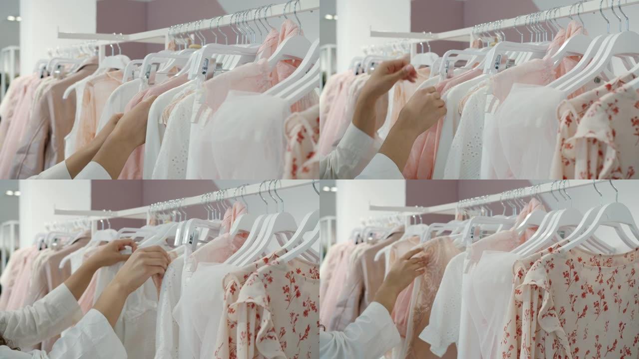 女人独自购物时，女性双手触摸衣架上的衣服的特写