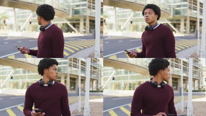 城市中的非裔美国人，在街上使用智能手机，戴着耳机和背包