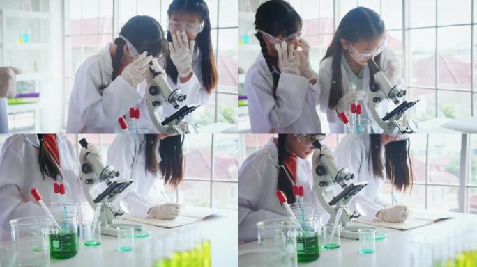 在生物学和科学课上使用显微镜与导师的特写小学生。STEM教育。