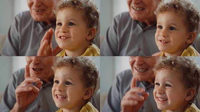 Kid和他的祖父之间令人振奋的时刻特写: 这个可爱的小男孩与他的祖父分享了他最喜欢的电视节目。老人看