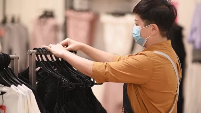 亚洲华人女性精品店服装店老板工作整理服装