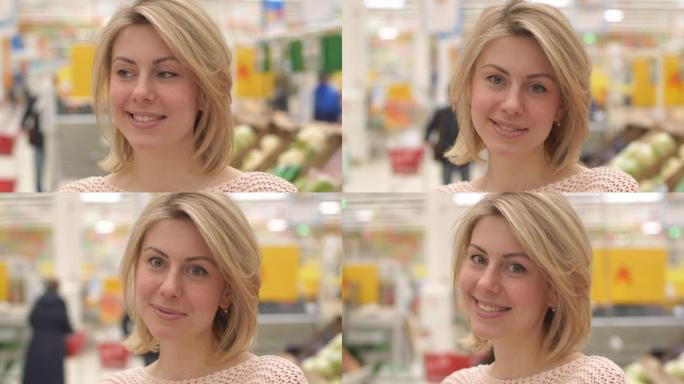 一个30岁无忧无虑的女性买家站在货架上的室内超市。孤身一人美女在商店购买天然新鲜食品和饮料。愉快和积
