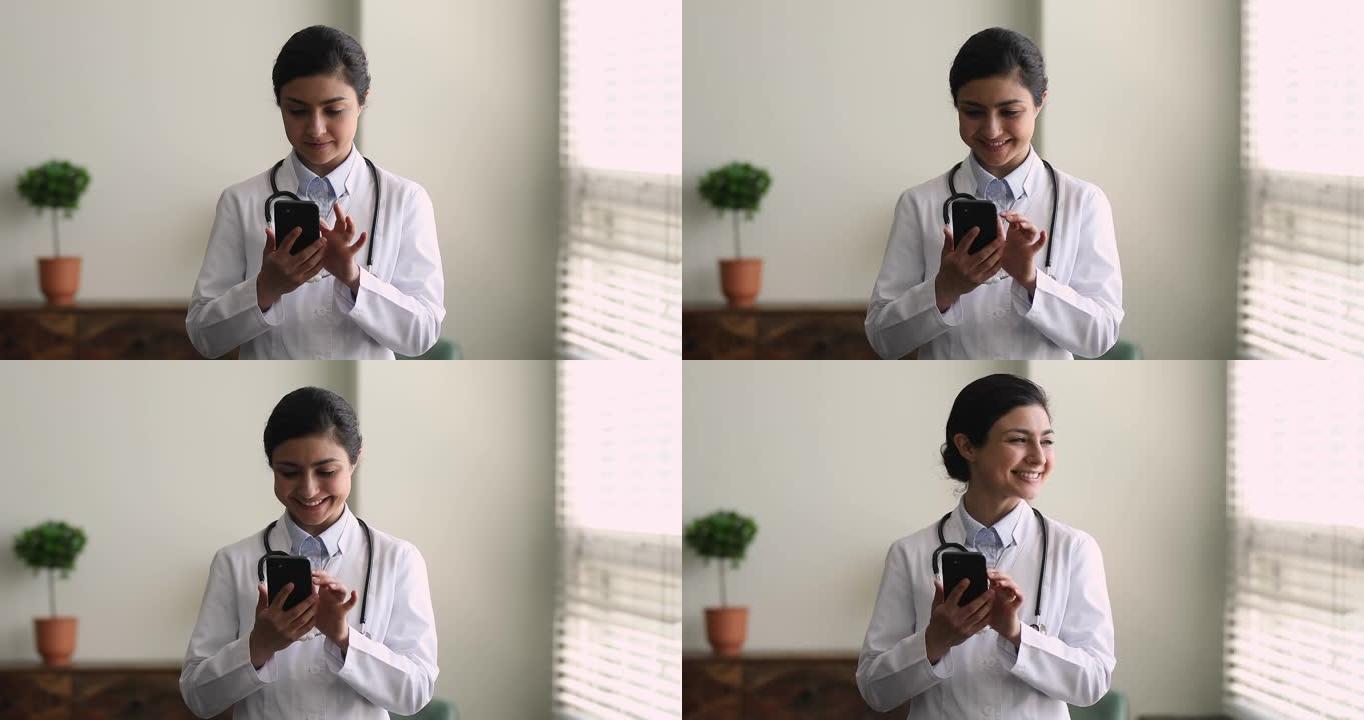 穿着制服的女医生拿着智能手机打字给病人的答案