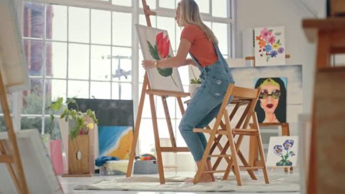 一位富有创造力的女艺术家在艺术工作室的花朵画布上绘画图像。一位专业画家使用画笔和调色板来创建彩色红色