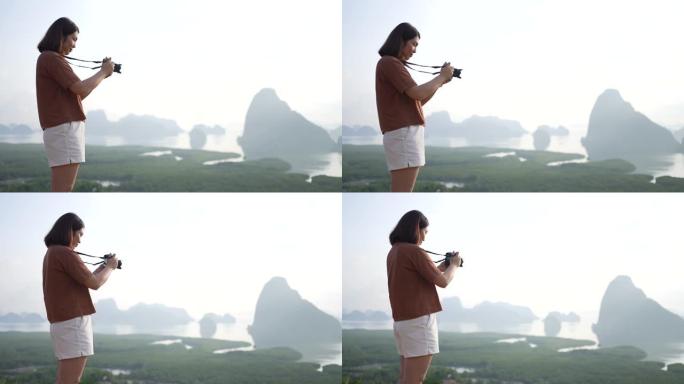 女人站在山上的视点上，在假期拍照