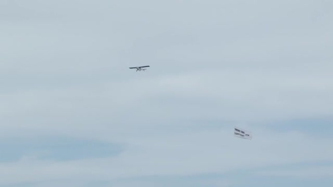 一架飞机在天空中飞行，在阿根廷大西洋沿岸拉白色横幅。