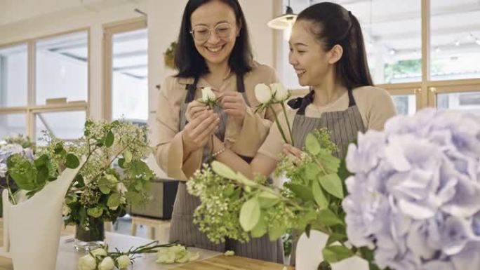 年轻的亚洲花店学习如何在车间布置花瓣的视频