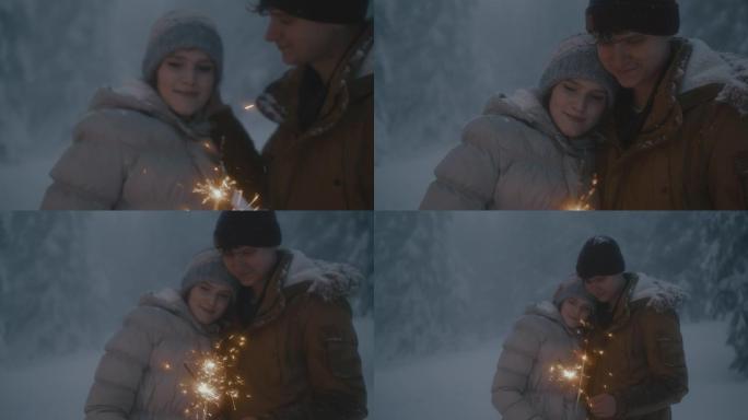 年轻夫妇在雪地里玩火花