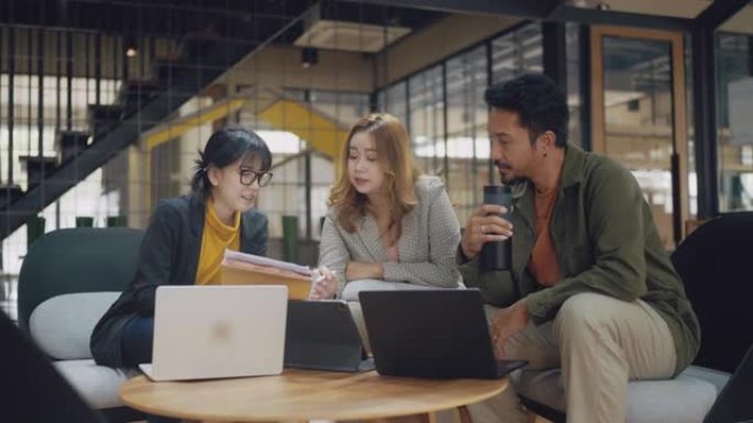 一群亚洲商人在现代办公室工作空间中一起工作。