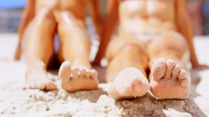 4k视频片段，两名妇女在沙滩上扭动脚趾
