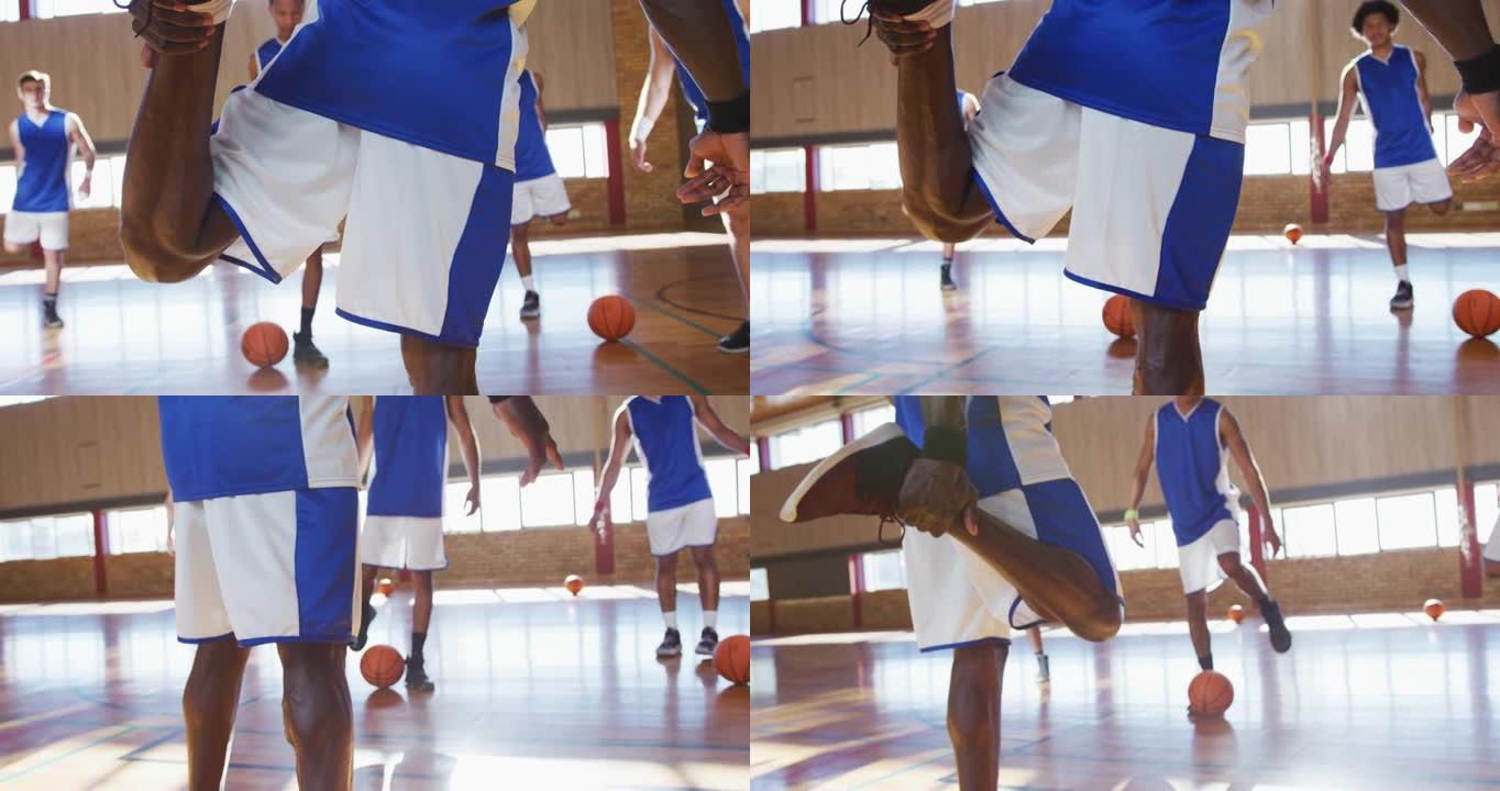 多样化的男子篮球队穿着蓝色运动服并伸展运动