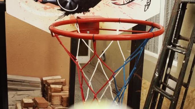 孩子打篮球，一个小男孩的手把球扔到他家院子里的篮子里。特写。