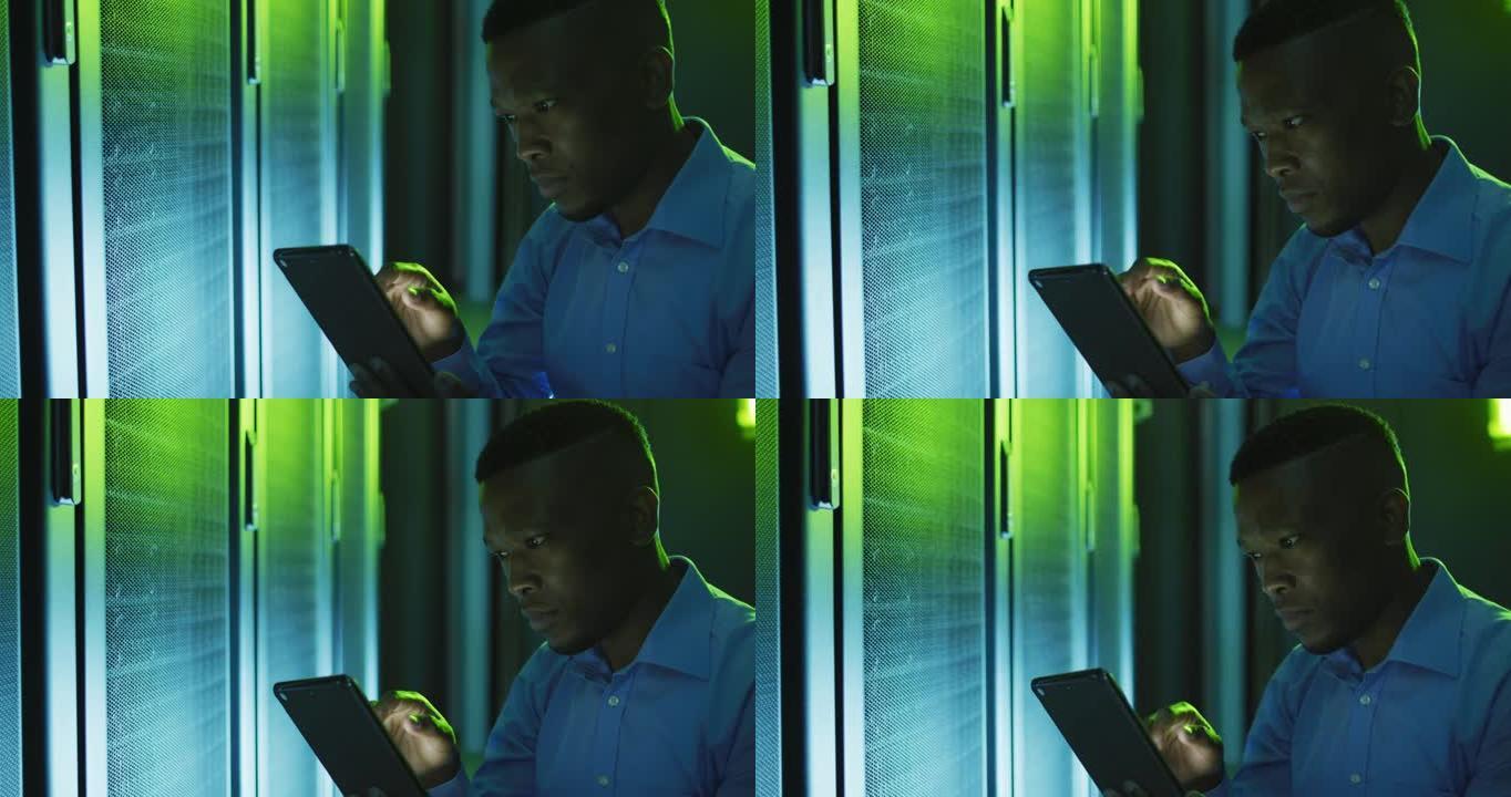 非裔美国男性计算机技术员使用平板电脑在商务服务器机房工作
