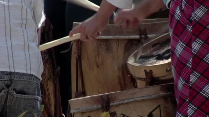 年轻人演奏典型的“Bombo Legüero”，这是阿根廷用木材和动物皮革制作的低音鼓。闭合。