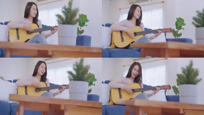 迷人的亚洲年轻成年女性喜欢在客厅弹吉他和唱歌