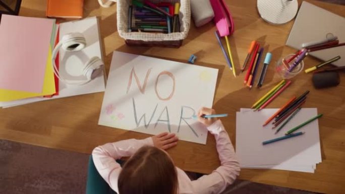 俯视图: 小女孩画文字没有战争!为了抗议邪恶，贪婪的人，他们只给我们美丽的星球带来贫困，暴力和破坏。