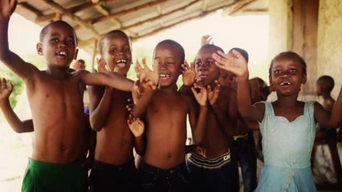 一群非洲儿童，在农村地区欢笑、跳跃和挥手。黑人孩子快乐地庆祝生活。相机捕捉童年的美丽和本质，乡村生活