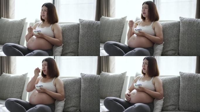 孕妇在家客厅沙发上吃健康食品