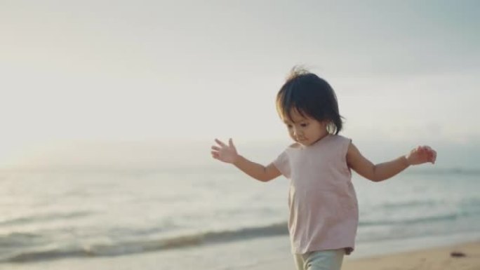 夏天日落时，亚洲家庭一起在海滩上散步。